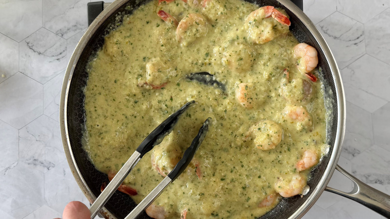 tossing prawns with tomatillo cilantro sauce