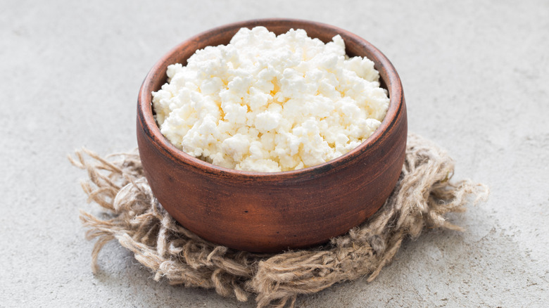 A close-up of a small clay bowl filled with cottage cheese
