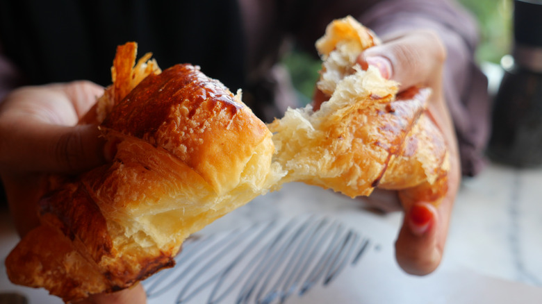 A buttery croissant being pulled apart
