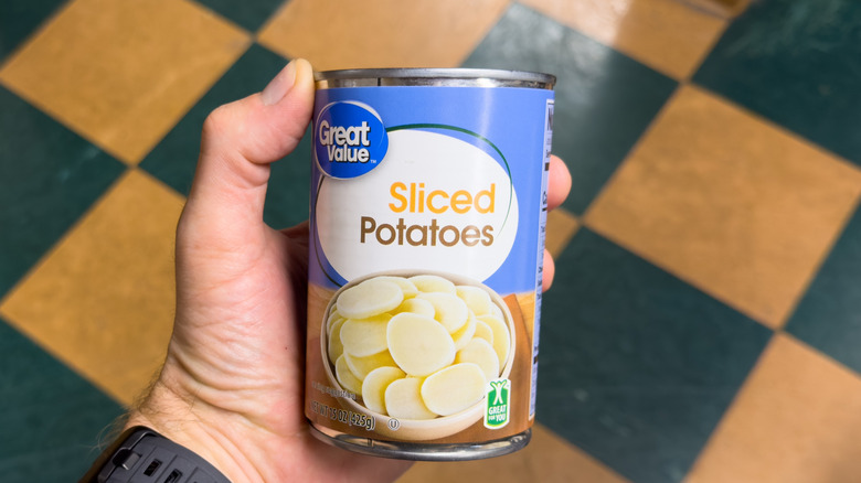 Someone holding a can of potatoes