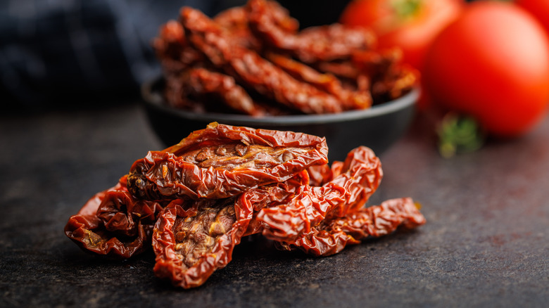 Sun dried red tomatoes on a black table