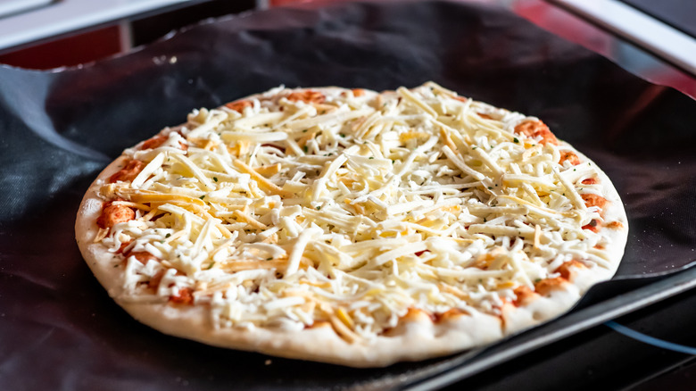 A close-up of a frozen cheese pizza ready to go in the oven