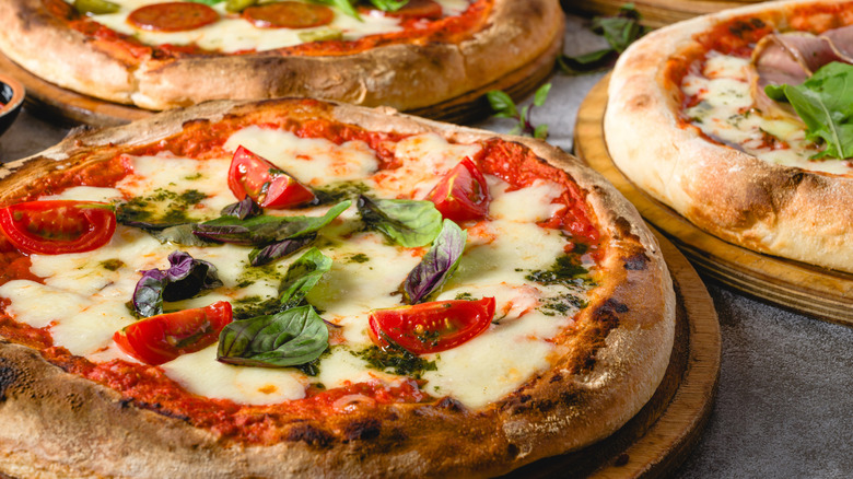 A close-up of a fresh Neapolitan pizza with tomato and herbs