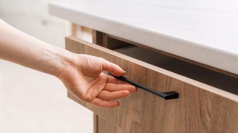 hand pulls a kitchen drawer open