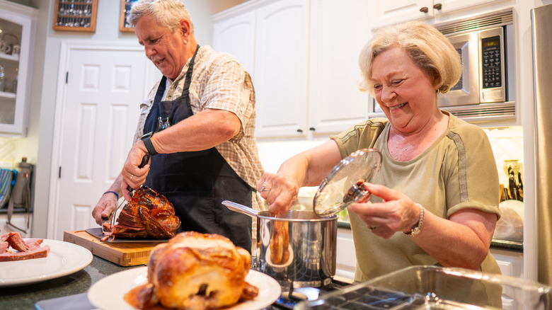Senior couple preparing dinner in kitchen
