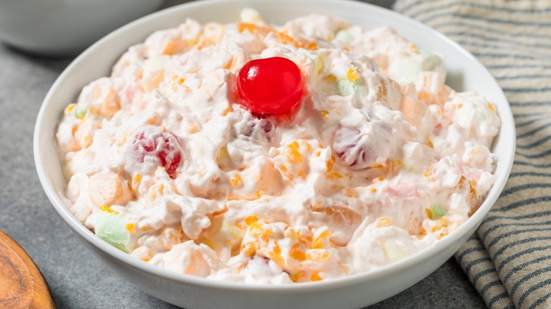 ambrosia salad in bowl with maraschino cherry