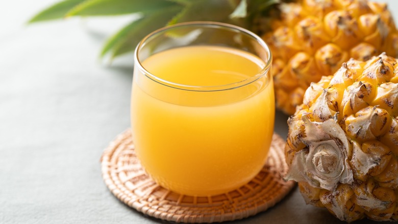 short glass of pineapple juice with fruit