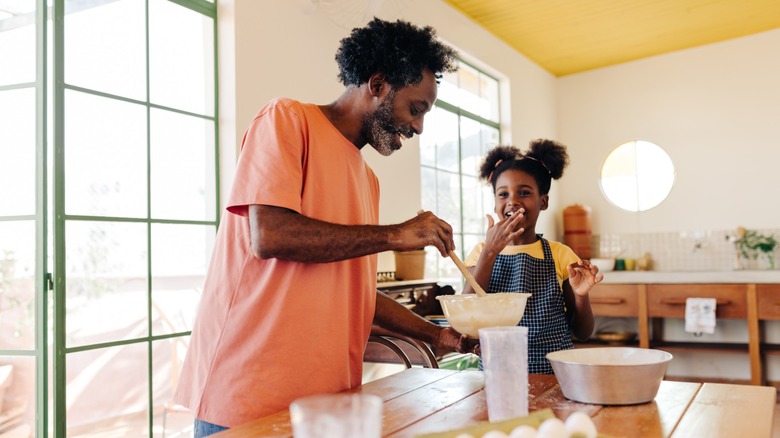 adult and child make cake together in kitchen