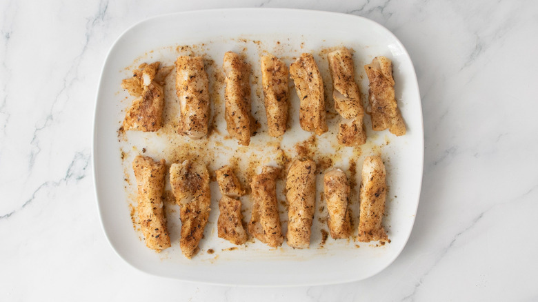 Grilled seasoned cod strips on plate
