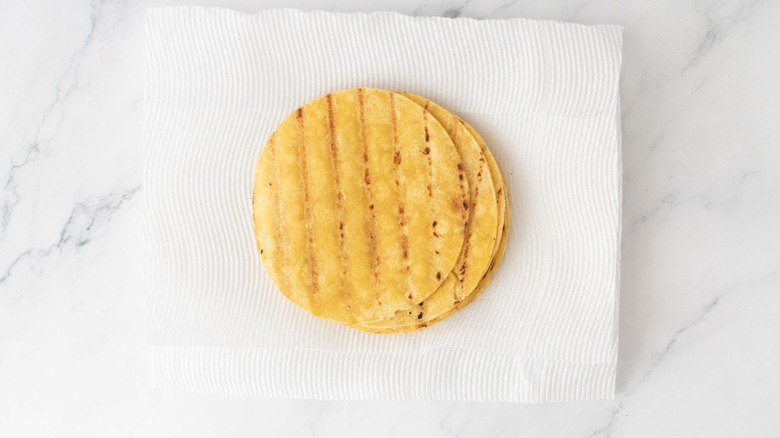 Tortillas stacked onto paper towels