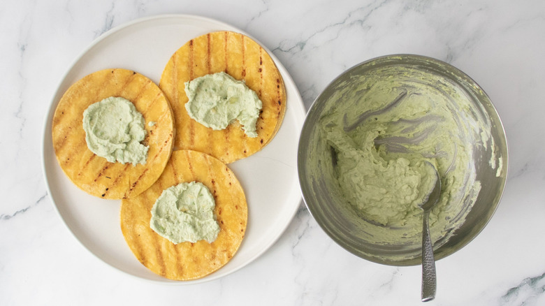 Tortillas with avocado spread next to avocado spread in bowl