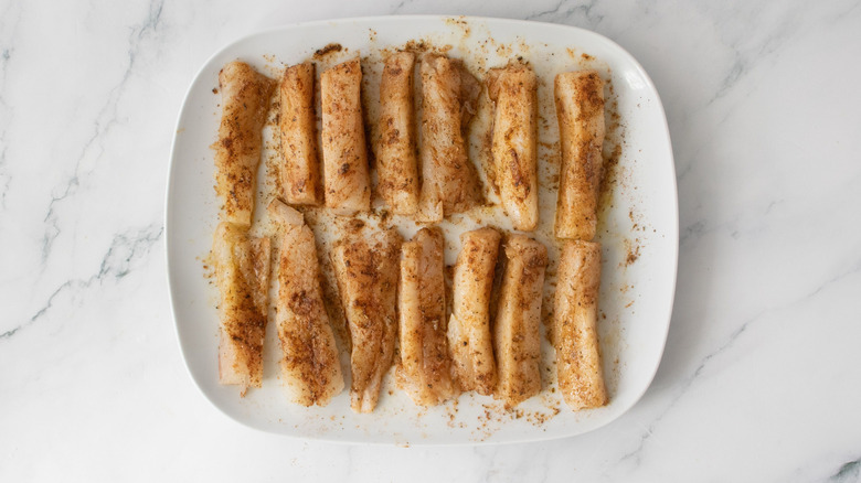Seasoned cod slices on plate