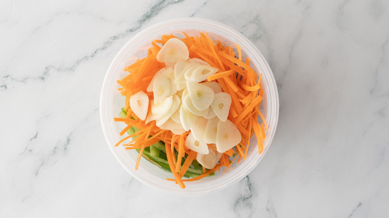 Sliced carrots and garlic in container