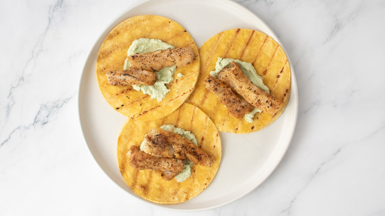 Tacos with avocado spread and grilled fish