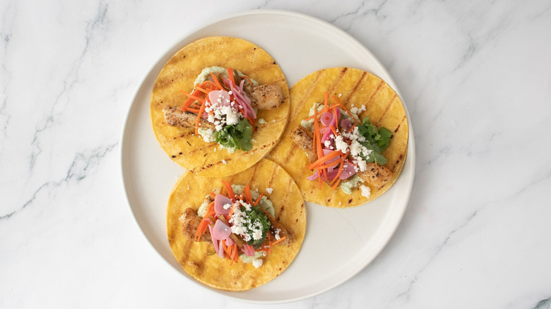 Grilled fish tacos with escabeche on plate