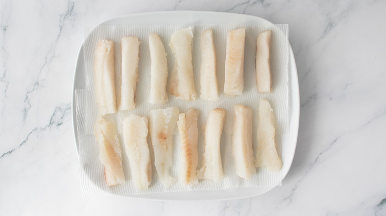 Thin cod slices on paper towels