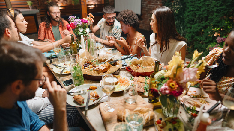 people eating around table at dinner party