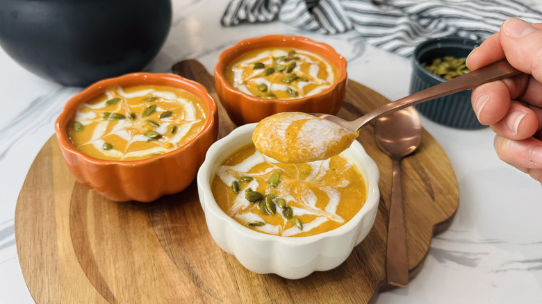 Spoon lifting bite out of bowl of pumpkin soup