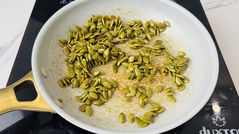 Seasoned pumpkin seeds in skillet