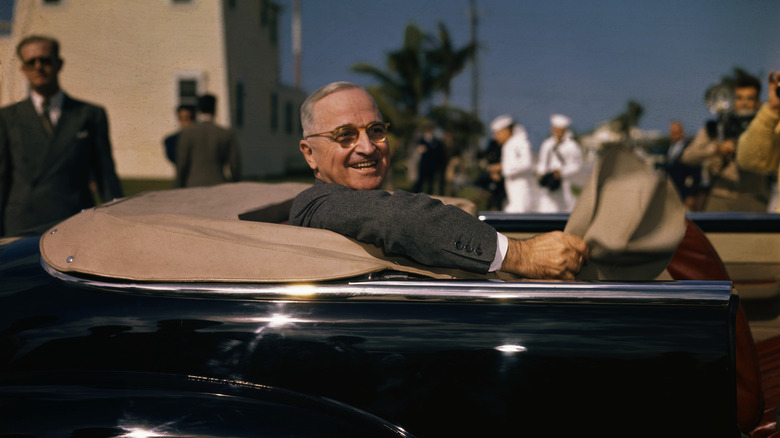 President Harry Truman smiles in convertible car