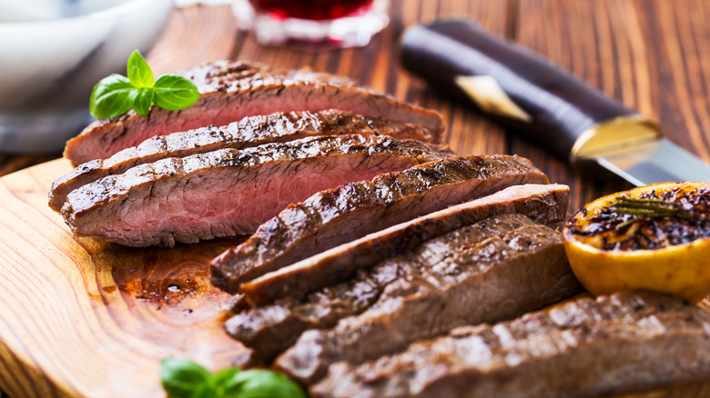 Cooked steak on a cutting board with knife