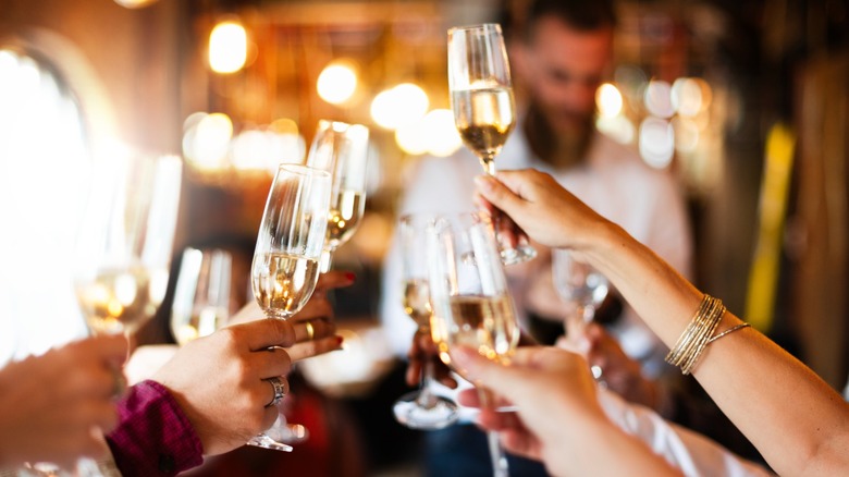 hands toasting with champagne flutes