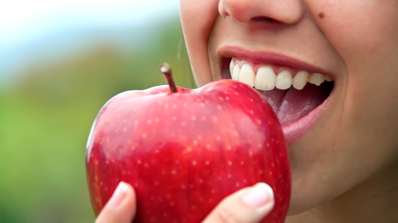 open mouth with ripe red apple
