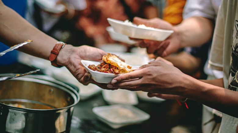Hands serving food to others
