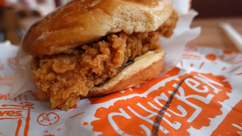 chicken sandwich from popeyes atop wrapper