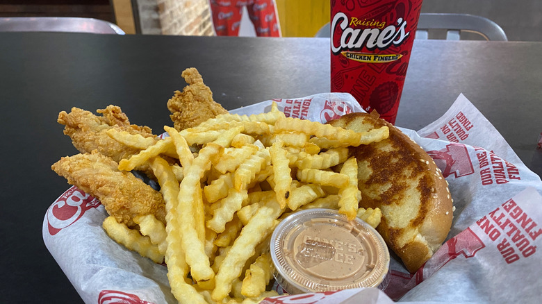 Closeup shot of Raising Cane's chicken meal with sauce container.