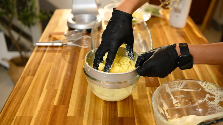 Gloves hands make fresh butter