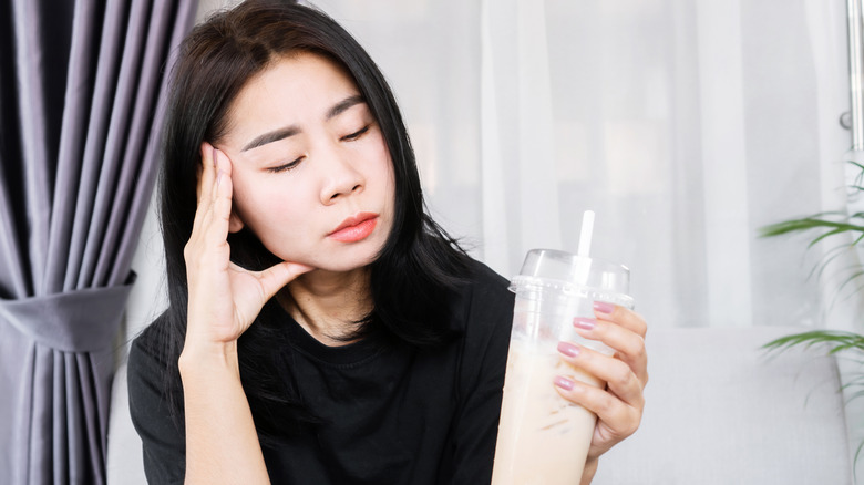 Woman having brain freeze after drinking iced coffee