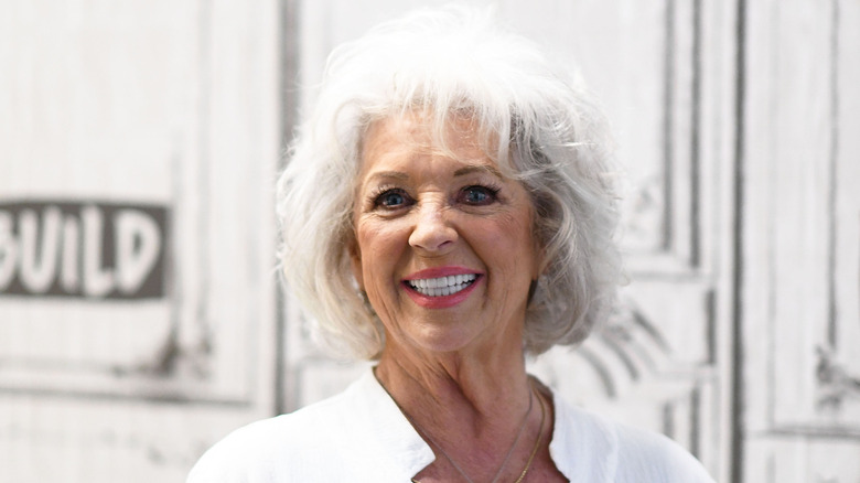 Paula Deen sonriendo y vistiendo una camisa blanca
