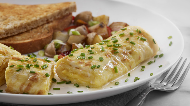 French omelet garnished with chives on a plate