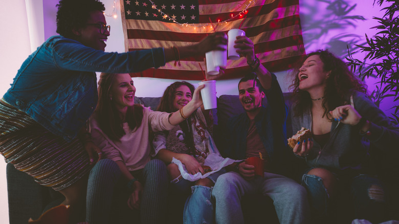 people sitting on a couch raising their cups