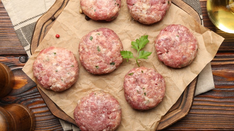 raw burger patties with herbs
