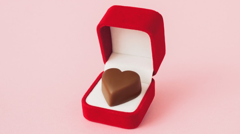 engagement ring box with a heart-shaped chocolate inside