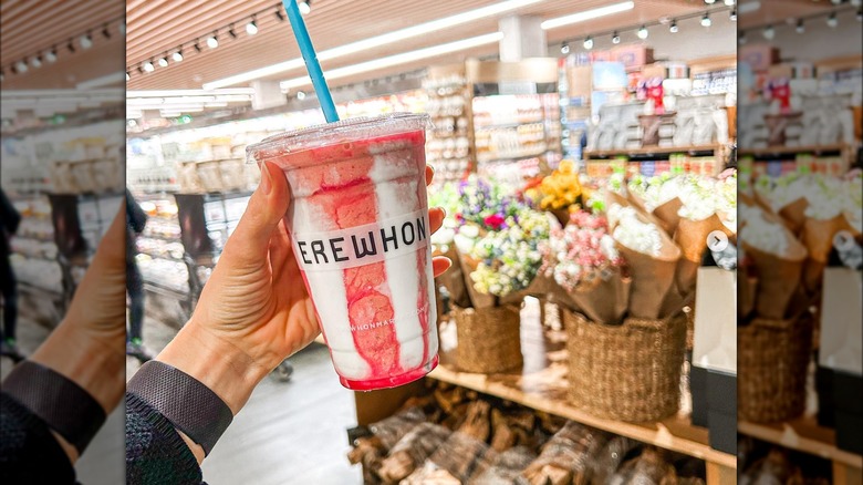 Hailey Bieber's Strawberry Glaze Skin Smoothie held in front of Erewhon store interior