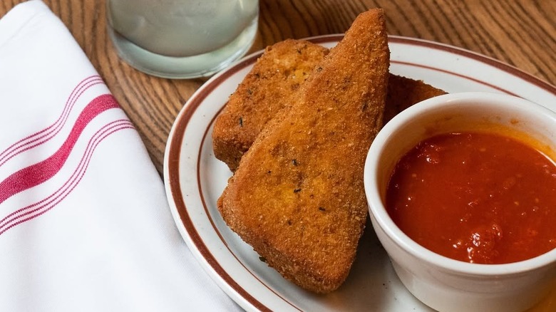 Mozzarella en carrozza on white plate with ramekin of marinara sauce