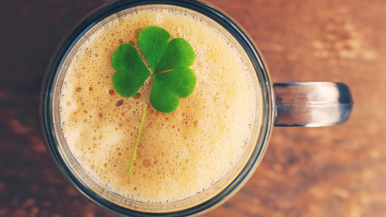 Foamy beer garnished with three-leaf clover