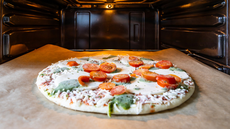 Frozen pizza on baking sheet in oven