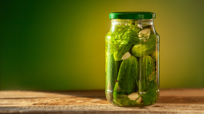 jar of pickles against a green background