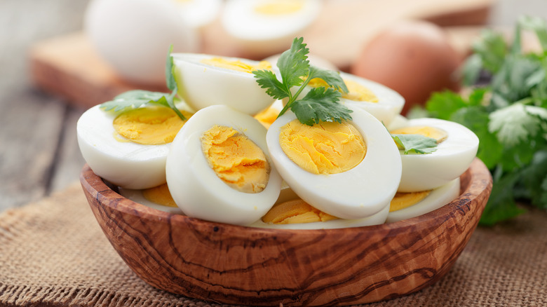 Hard-boiled egg halves in a wooden bowl