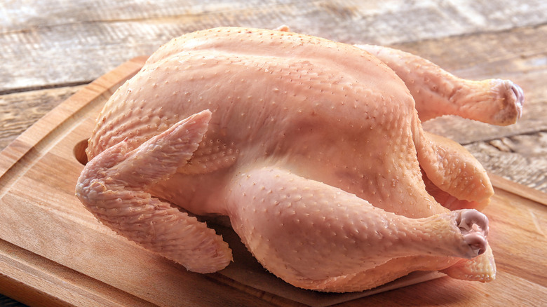 Raw turkey on wooden cutting board