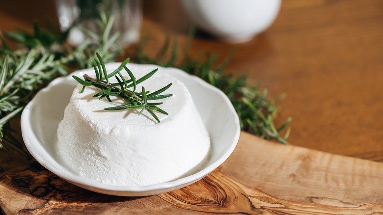 Ricotta cheese and fresh herbs in a white bowl