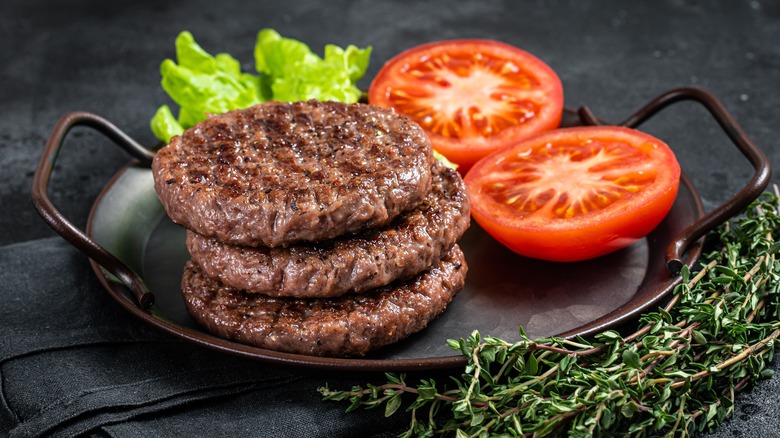 Cooked burger patties in black pan