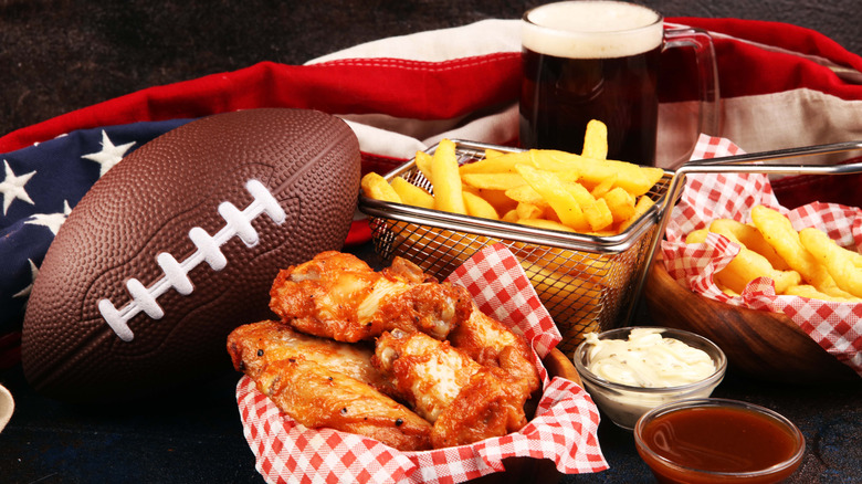 Chicken wings, snacks, beer, and football with an American flag