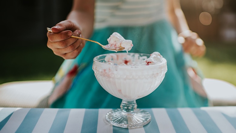 a person in a dress enjoys an ice cream sundae