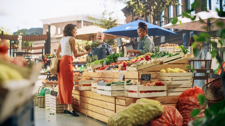 woman buys produce at a farm stand
