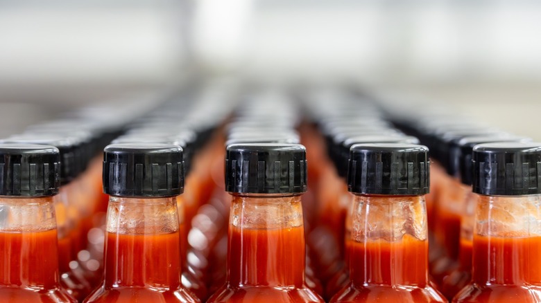 bottles of hot sauce with black caps